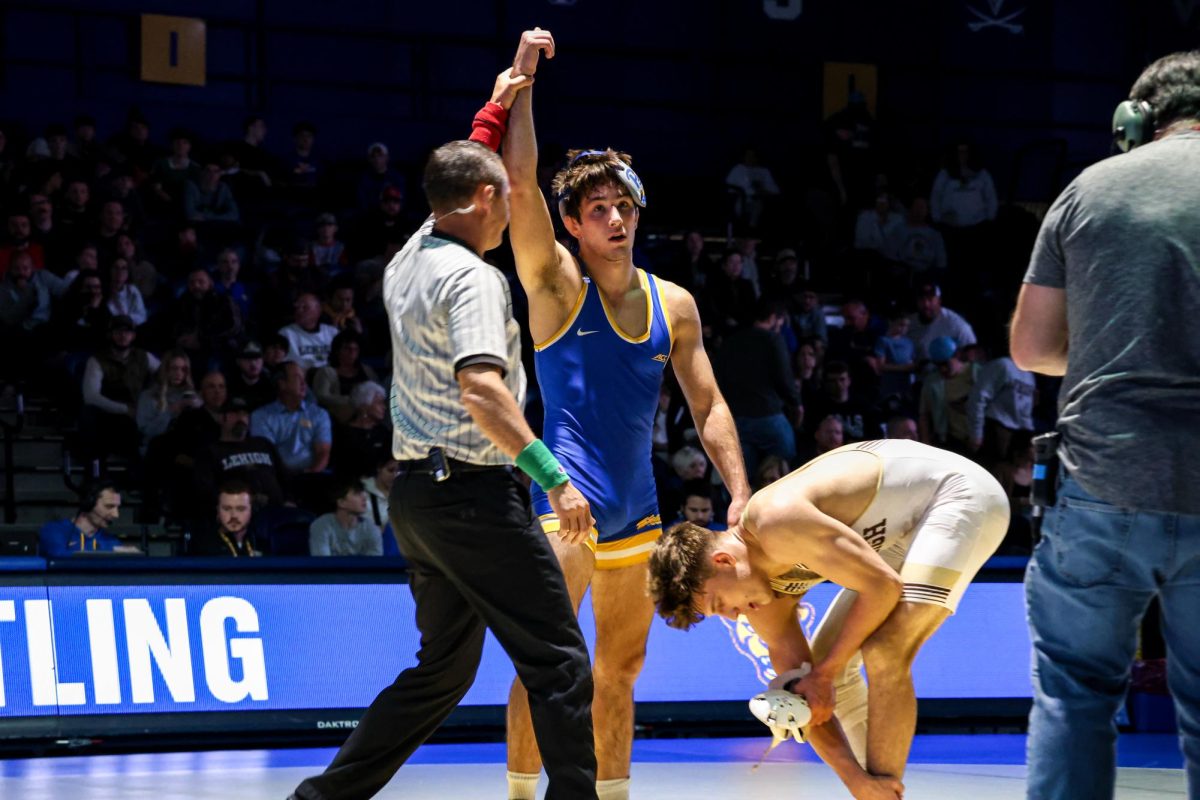 A referee holds up the hand of a victorious Pitt wrestler during the match against Lehigh in the Fitzgerald Field House on Sunday, Nov. 24.
