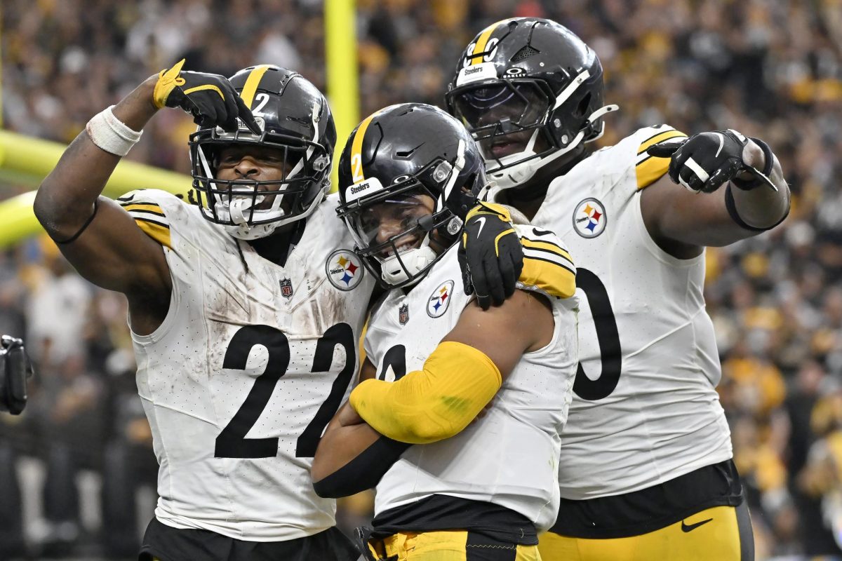 Pittsburgh Steelers quarterback Justin Fields, middle, is congratulated by running back Najee Harris (22) and tight end Darnell Washington after scoring against the Las Vegas Raiders during the second half of an NFL football game in Las Vegas, Sunday, Oct. 13, 2024.