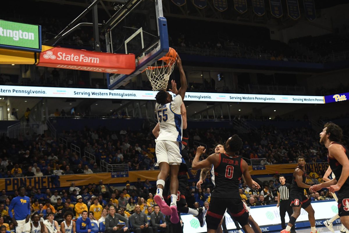 Redshirt senior forward Zach Austin (55) attempts a reverse dunk during Pitt men’s basketball’s game against Stanford at the Petersen Events Center on Saturday, Jan. 5.