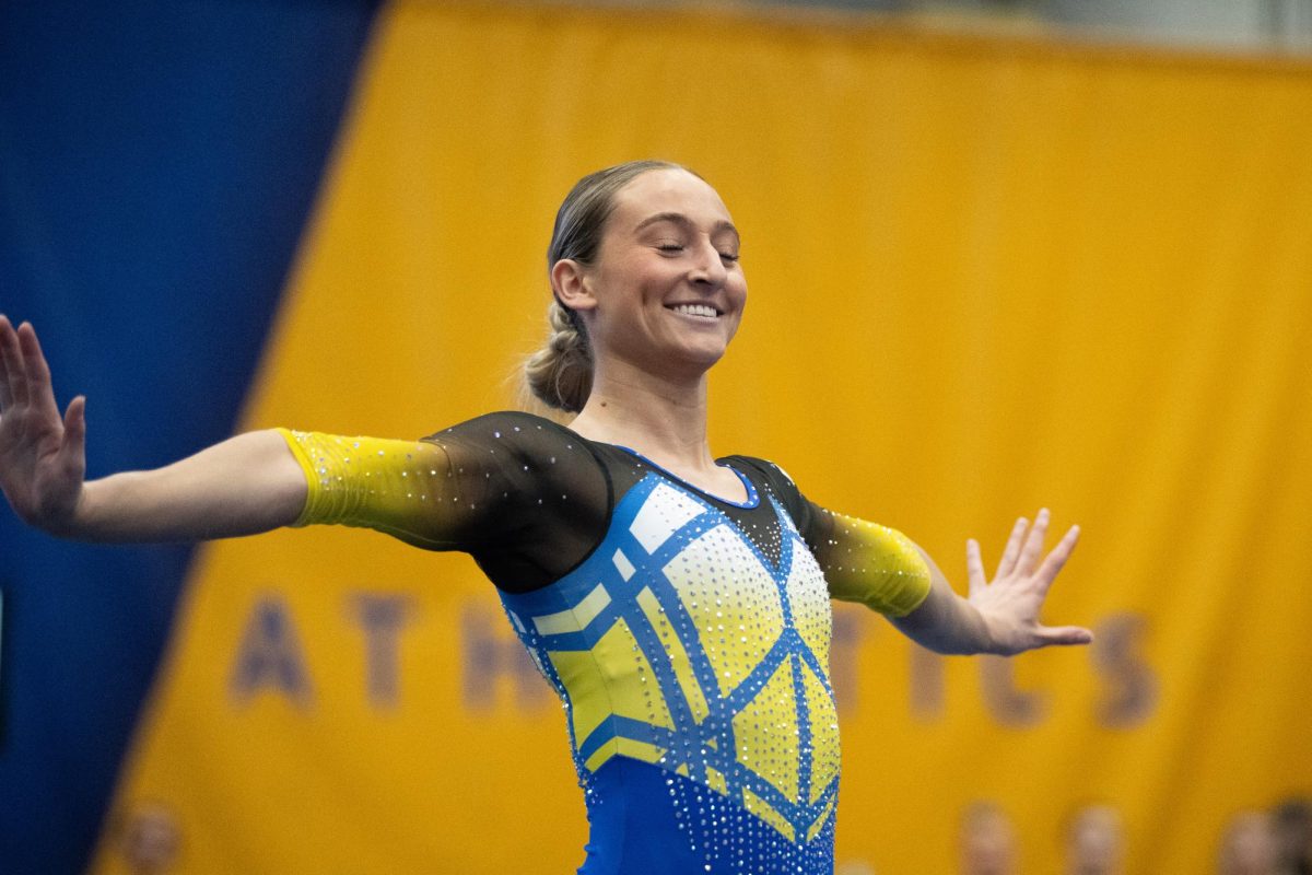 A Pitt gymnast smiles and poses during the meet against Stanford in the Fitzgerald Field House on Sunday, Jan. 26.
