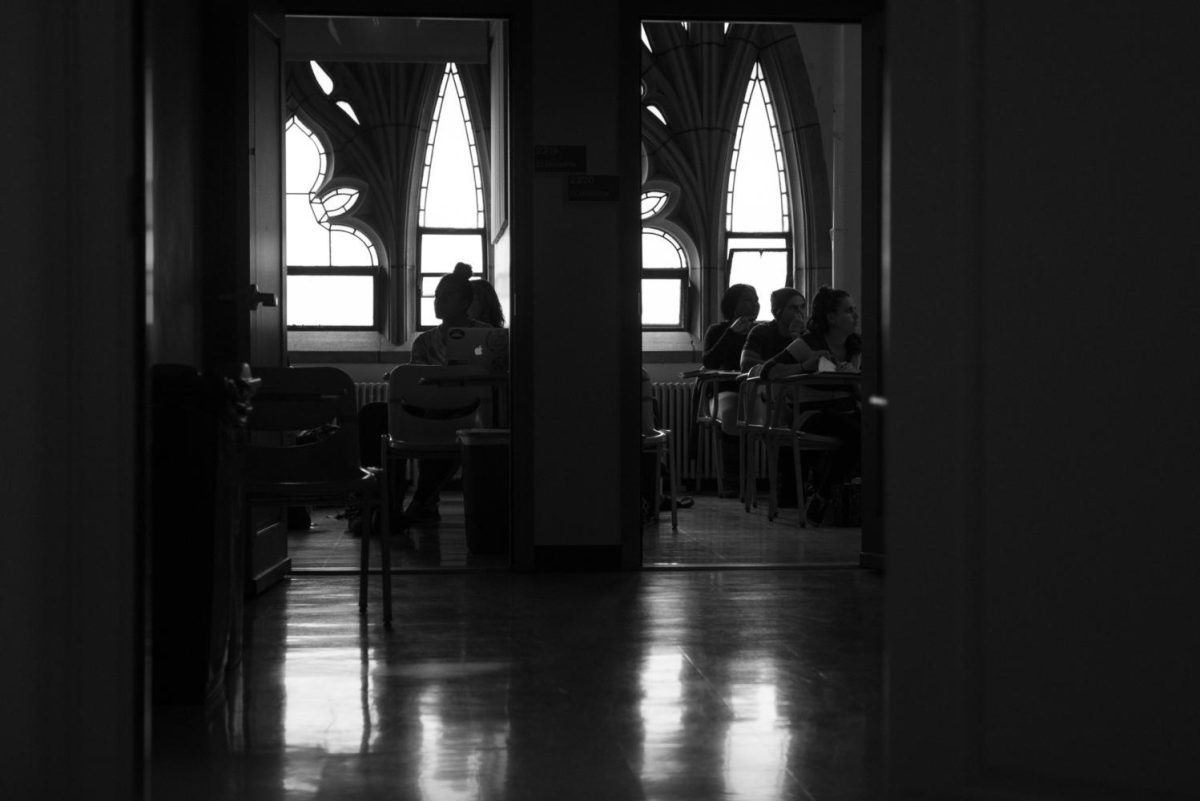 Students in two classrooms listen to lectures.