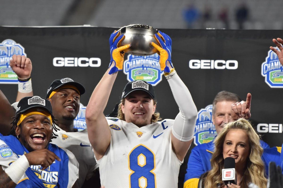 Pitt quarterback Kenny Pickett (8) displays the ACC Championship trophy.