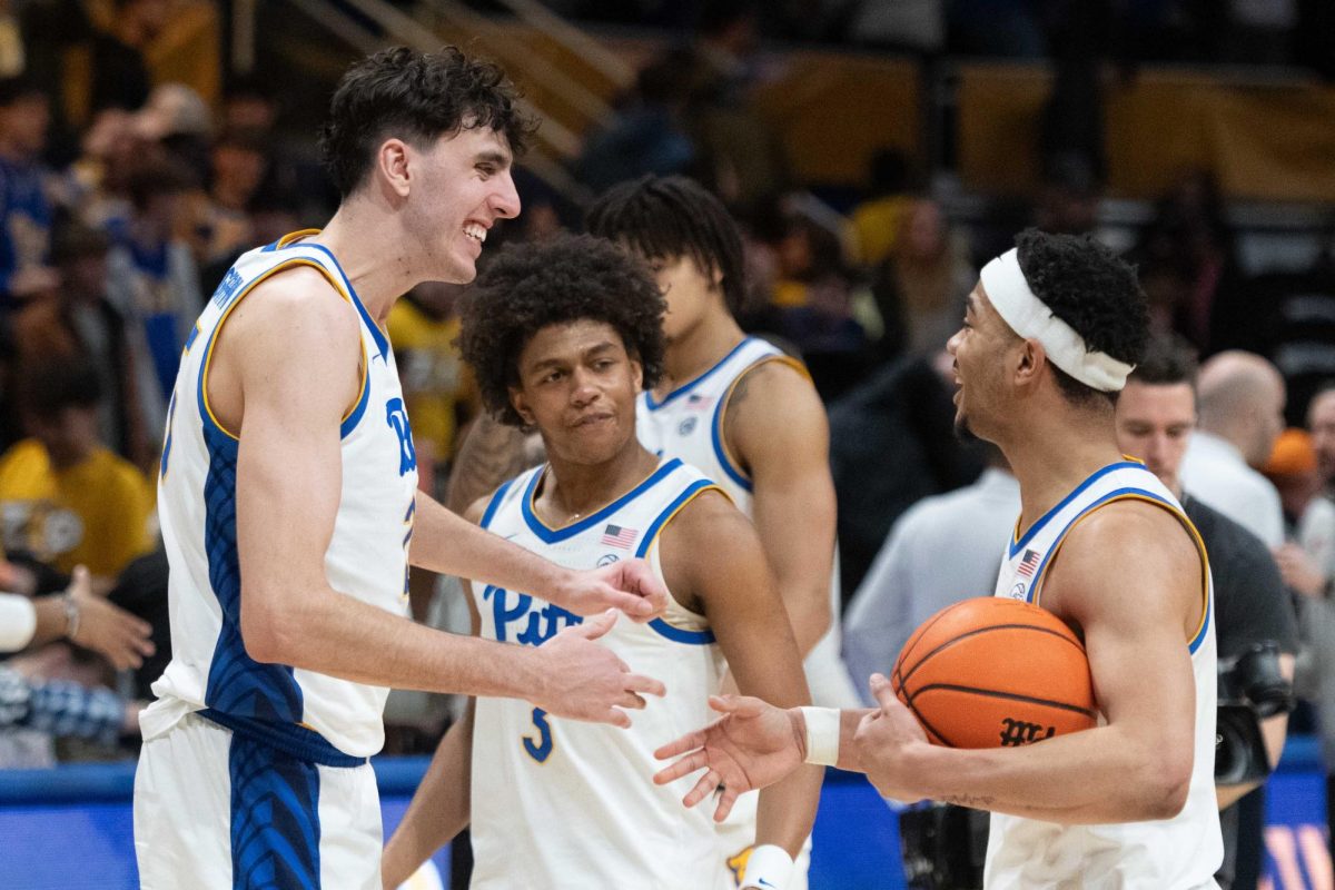 Junior forward Guilliermo Diaz Graham (25) and senior guard Ishmael Leggett (5) celebrate during Pitt men’s basketball’s game against Syracuse on Tuesday, Feb. 18 at the Petersen Events Center.