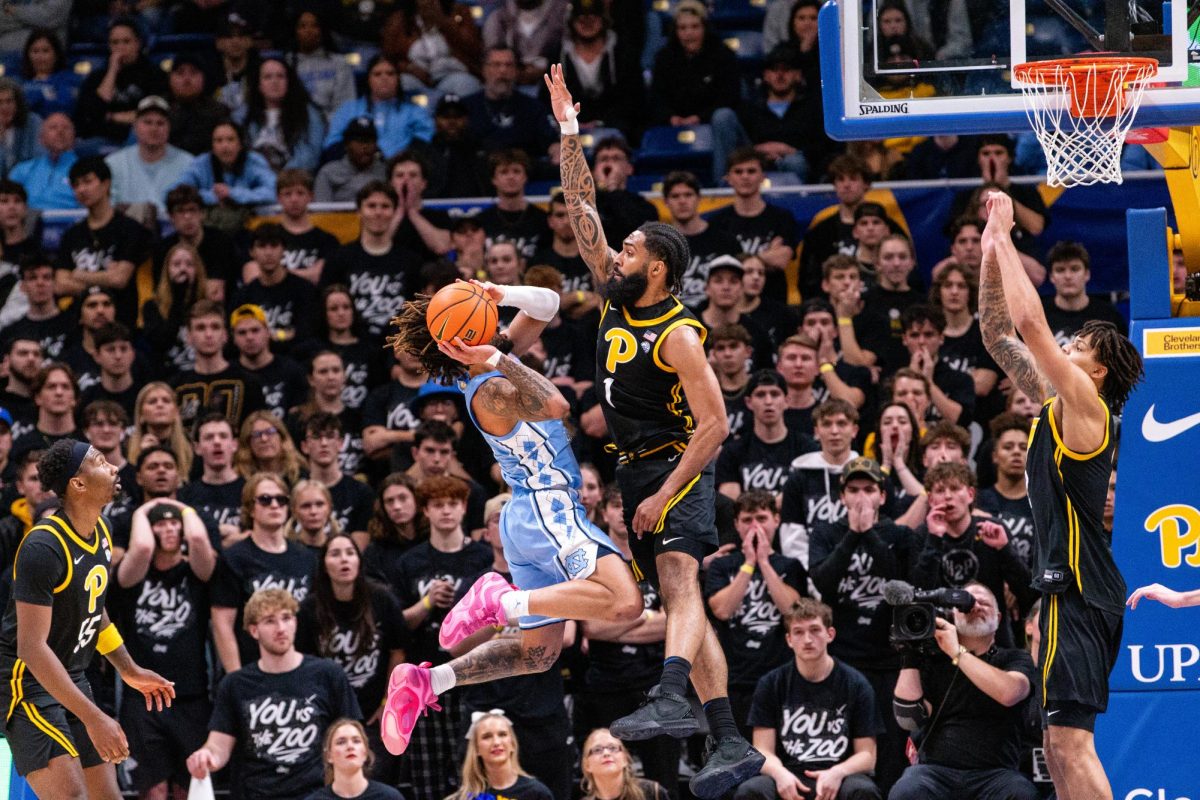 Graduate student Damian Dunn (1) goes for a block during Pitt men’s basketball’s game against UNC on Jan. 28 at the Petersen Events Center.