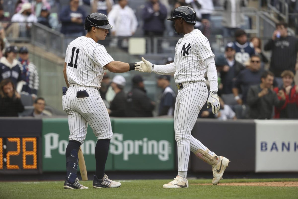 New York Yankees' Anthony Volpe, left, and Jazz Chisholm Jr., right, react after Chisholm Jr. hit a home run during the eighth inning of a baseball game against the San Francisco Giants Sunday, April 13, in New York.
