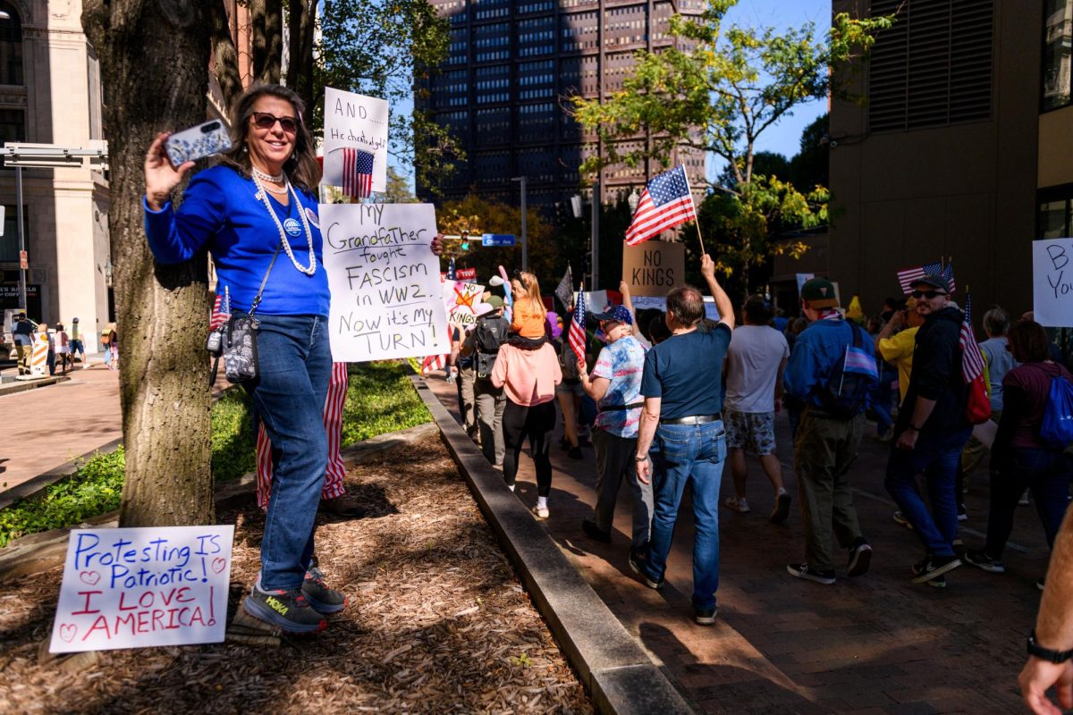 A protester holds a sign reading “My Grandfather fought Fascism in WW2. Now it’s my TURN!” at the “No Kings” protest in downtown Pittsburgh on Oct. 19, 2025.
