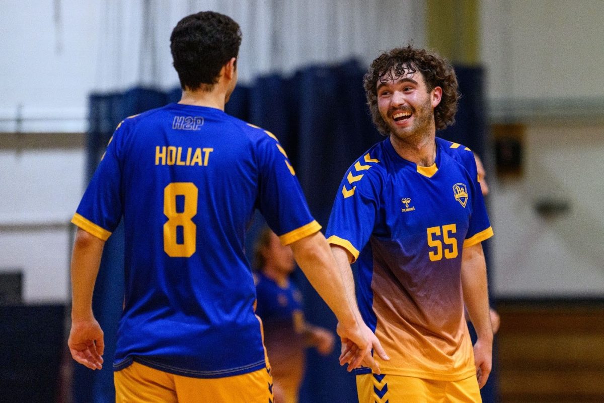 Players on the Pitt club handball team high-five.