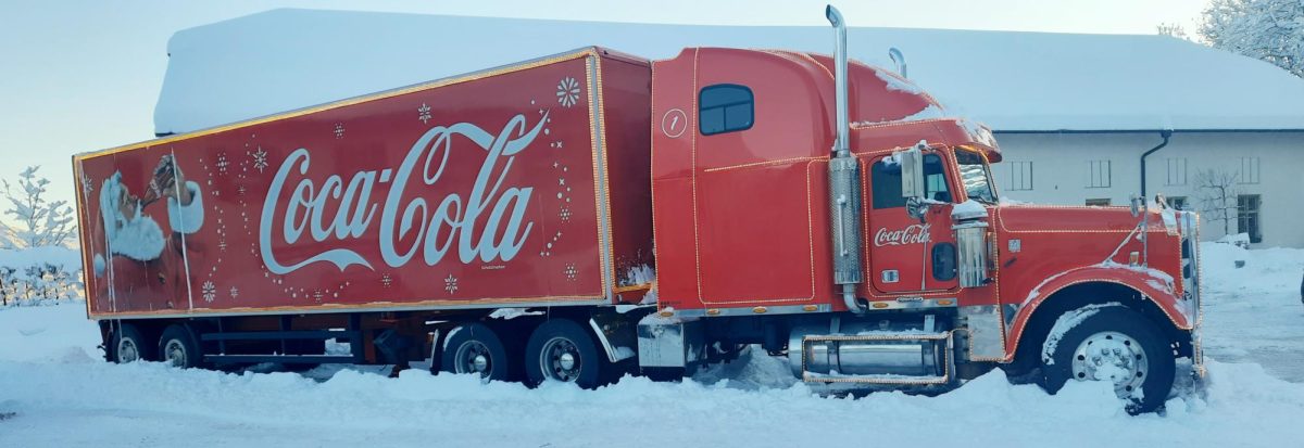 A Coca-Cola branded truck sits in the snow.